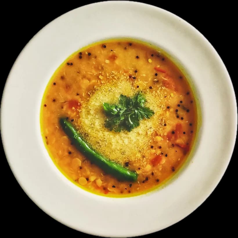 A bowl of cholar dal with a green chilli