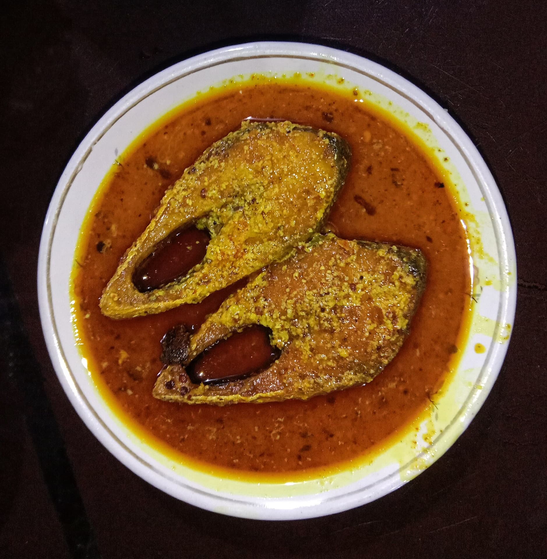 Two hilsa steaks in a mustard gravy
